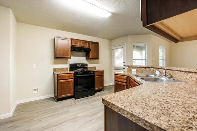 a kitchen with stainless steel appliances granite countertop a sink and a stove