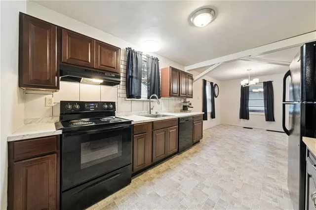 a kitchen with stainless steel appliances granite countertop a sink stove and cabinets