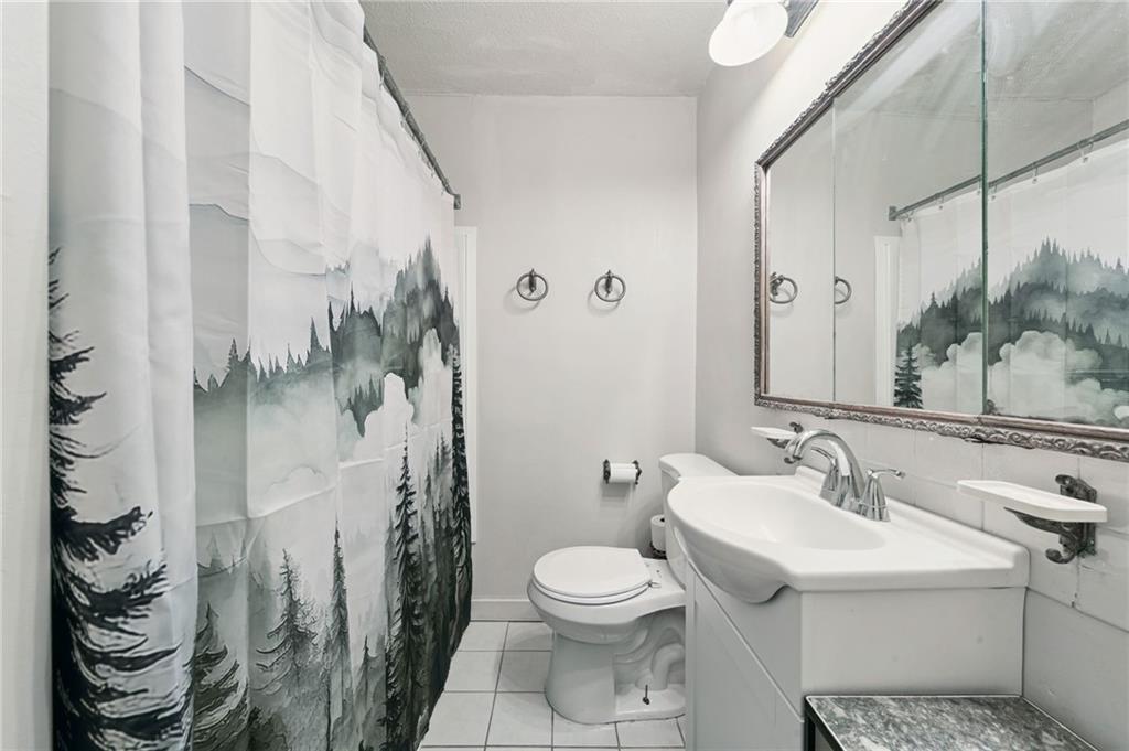 2052 McKinney Road Monroeville, PA 15146 - Photo 20 of 30 a bathroom with a sink a toilet and shower curtain