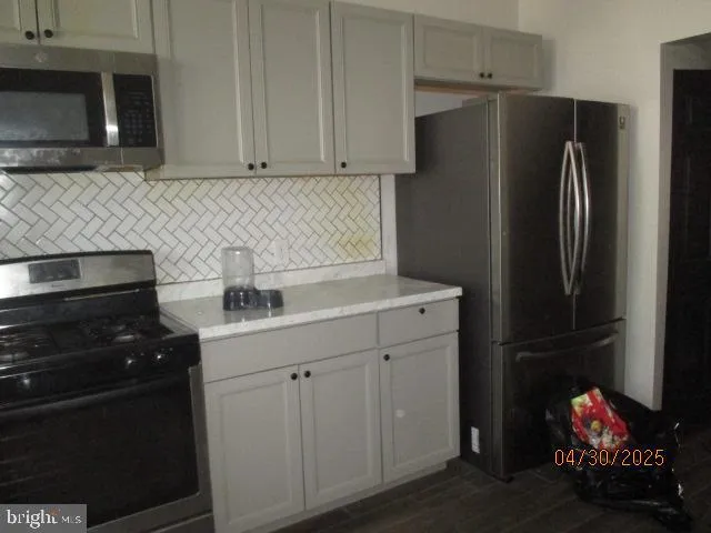 a kitchen with a refrigerator stove and cabinets