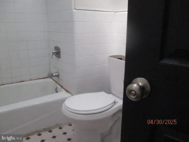 a white toilet sitting next to a bath tub and a shower