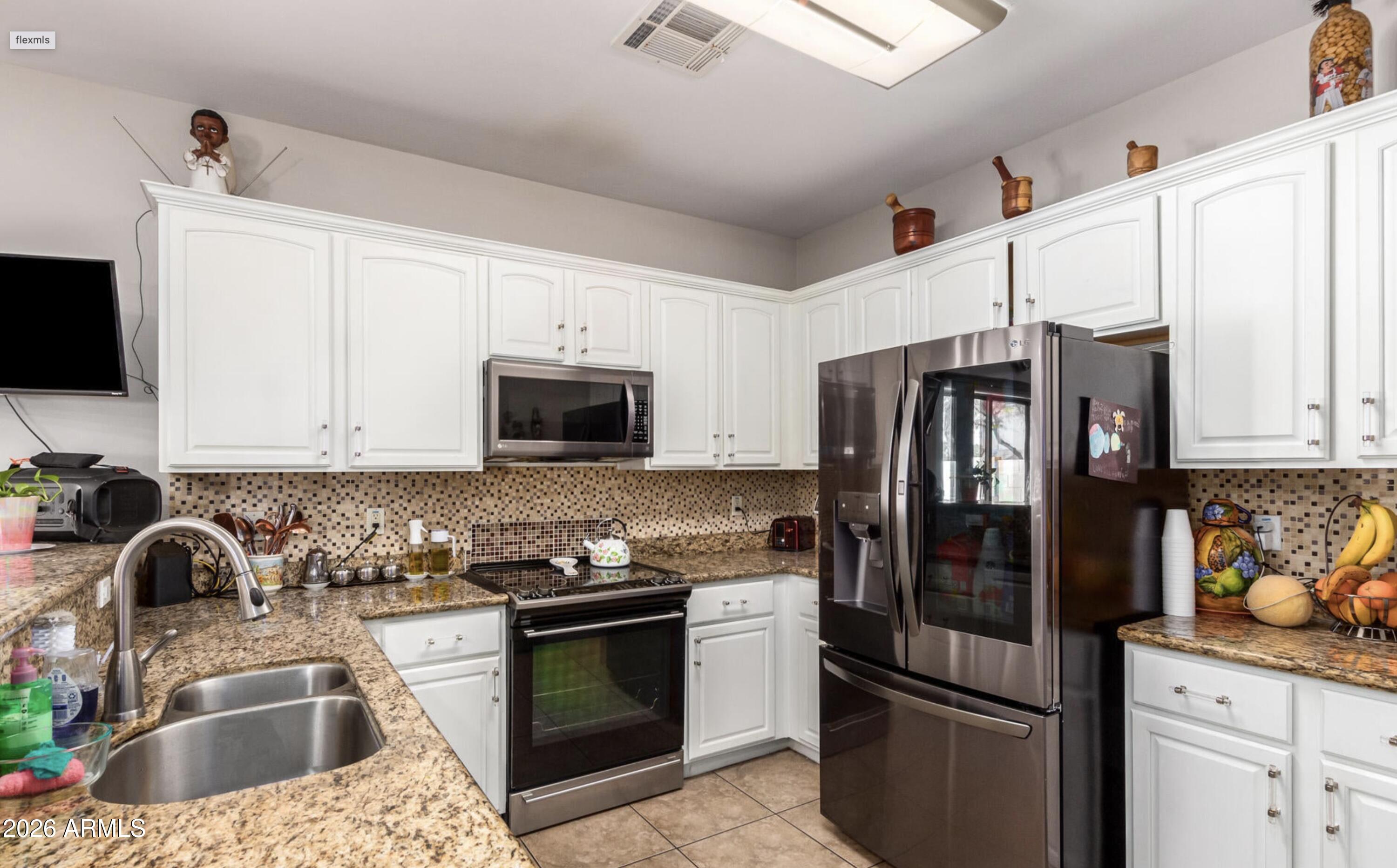10225 West Camelback Road, Unit 12 Phoenix, AZ 85037 - Photo 8 of 19 a kitchen with granite countertop a refrigerator stove and sink