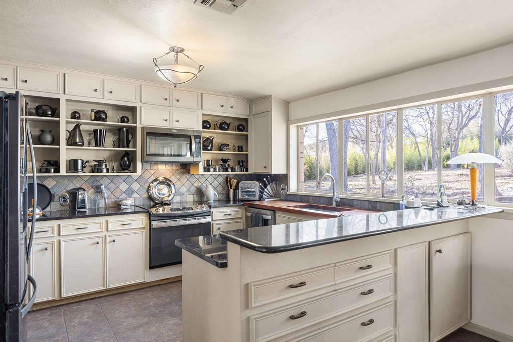 228 Galbraith Avenue Kerrville, TX 78028 - Photo 13 of 50 a kitchen with stainless steel appliances a sink a stove and cabinets