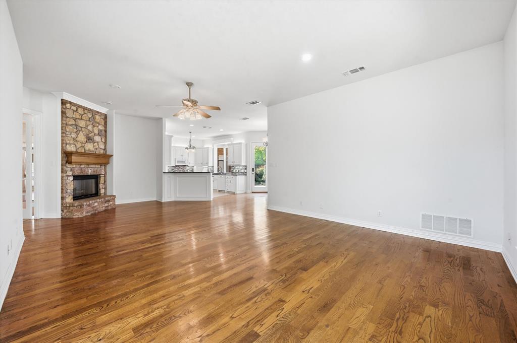 5513 Rustic Trail Colleyville, TX 76034 - Photo 11 of 40 a view of a kitchen and an empty room with wooden floor