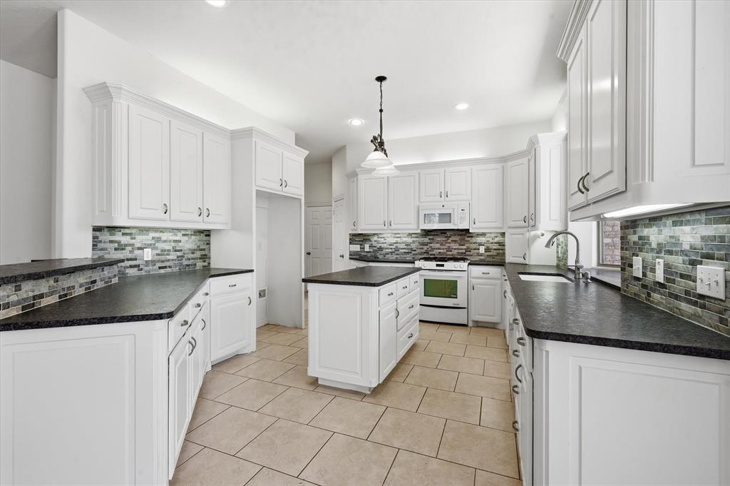 5513 Rustic Trail Colleyville, TX 76034 - Photo 15 of 40 a kitchen with granite countertop a sink a counter top space appliances and cabinets