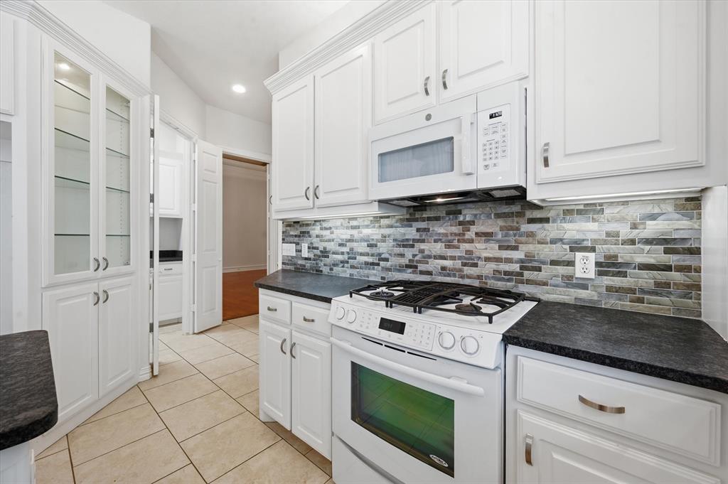5513 Rustic Trail Colleyville, TX 76034 - Photo 17 of 40 a kitchen with white cabinets and appliances