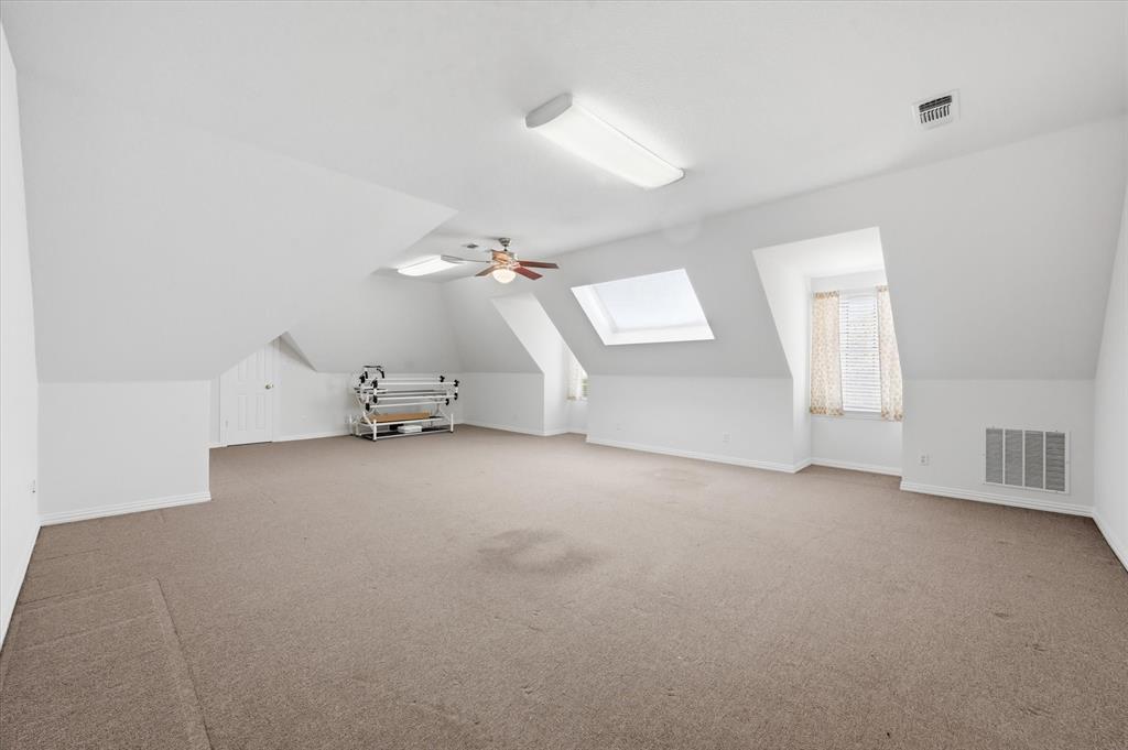 5513 Rustic Trail Colleyville, TX 76034 - Photo 21 of 40 an empty room with a chandelier fan and windows