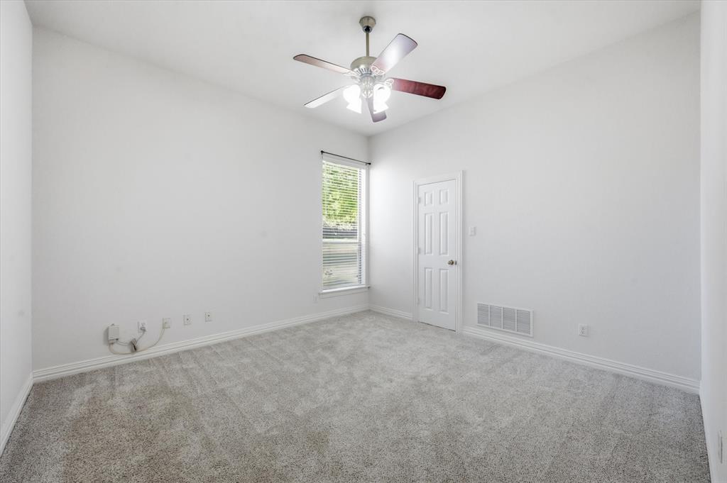 5513 Rustic Trail Colleyville, TX 76034 - Photo 24 of 40 an empty room with a chandelier fan and windows