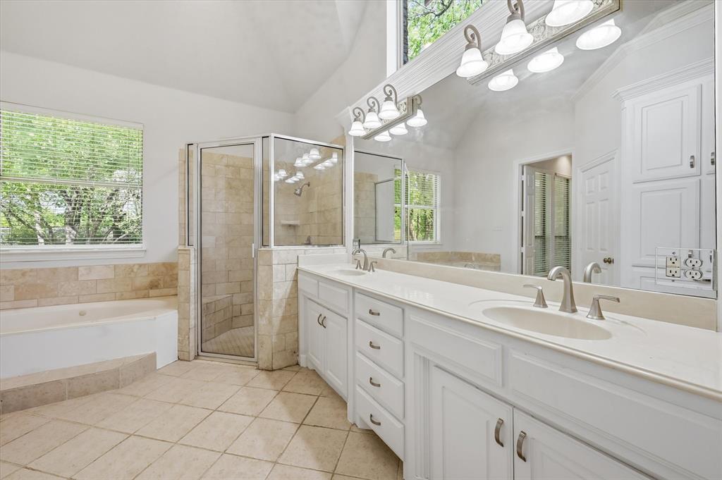 5513 Rustic Trail Colleyville, TX 76034 - Photo 31 of 40 a spacious bathroom with a granite countertop sink a large mirror a shower and a bathtub