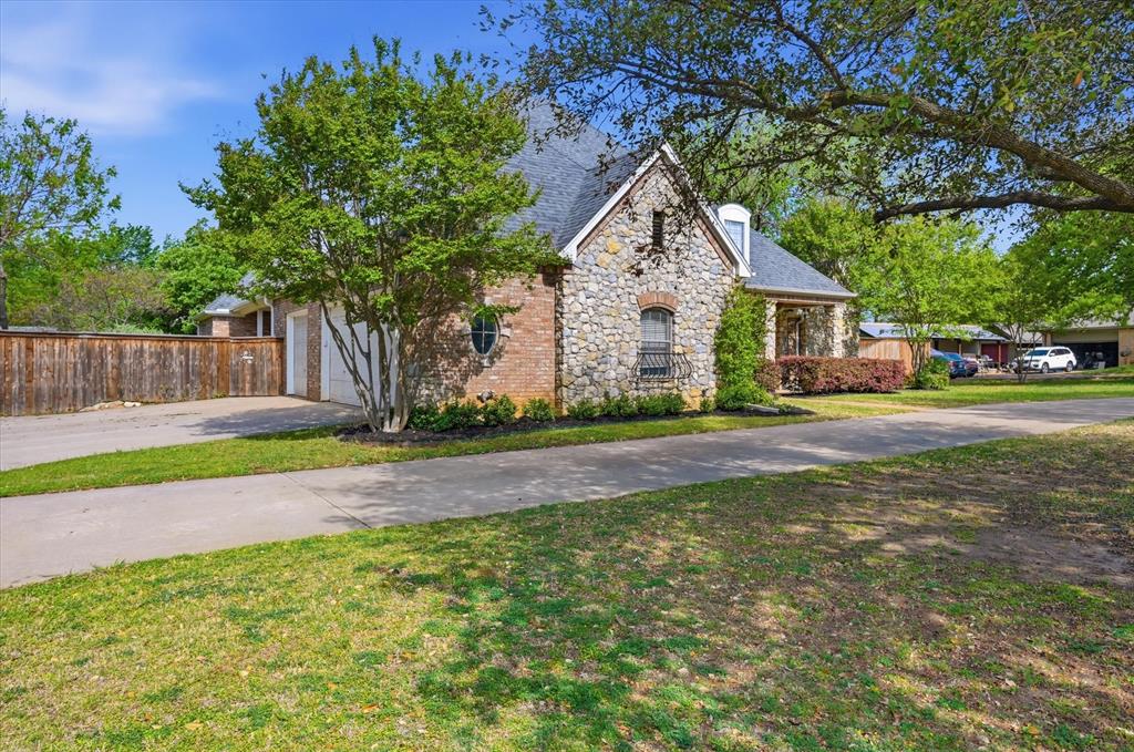 5513 Rustic Trail Colleyville, TX 76034 - Photo 4 of 40 a front view of a house with a yard and garage