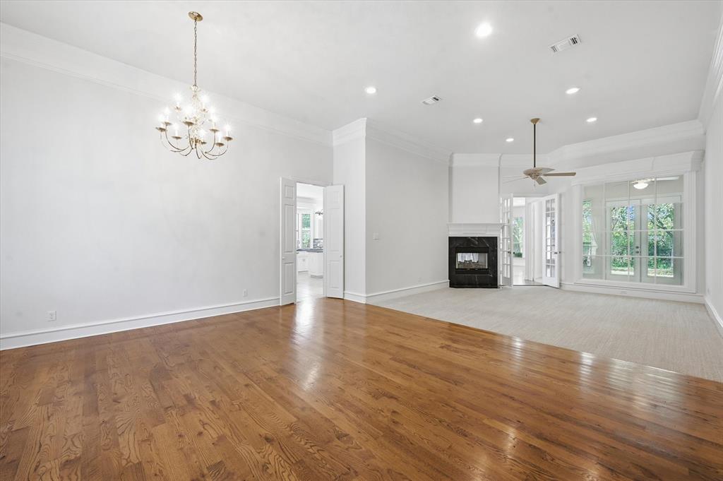 5513 Rustic Trail Colleyville, TX 76034 - Photo 6 of 40 an empty room with wooden floor fireplace and windows
