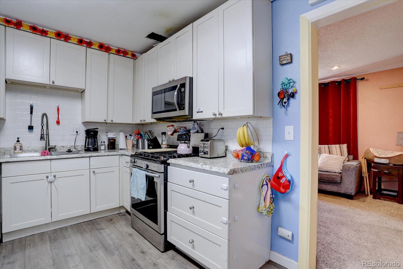 775 Victor Street Aurora, CO 80011 - Photo 9 of 21 a kitchen with a sink cabinets and window
