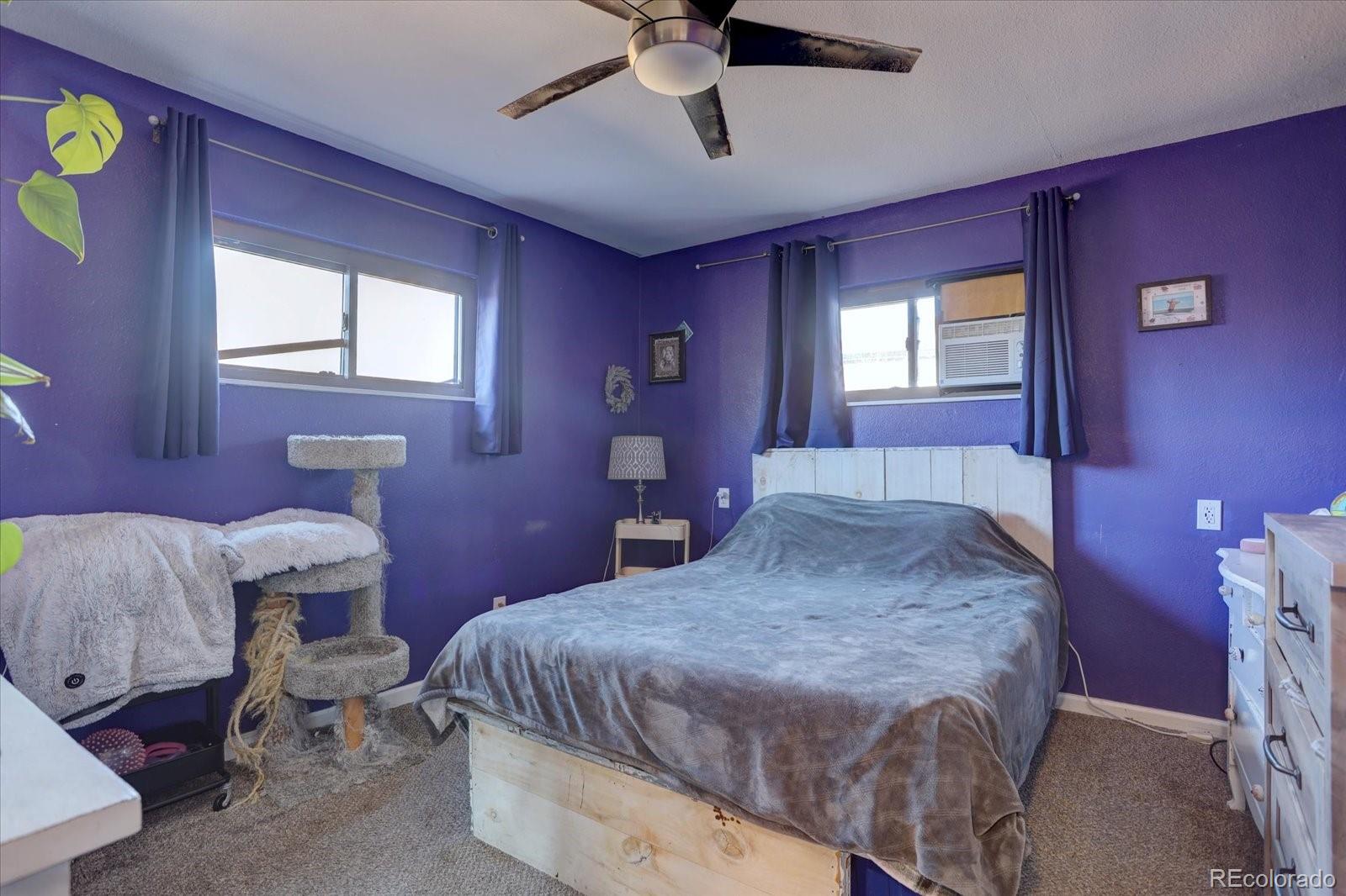 775 Victor Street Aurora, CO 80011 - Photo 10 of 21 a bedroom with a bed and a chandelier