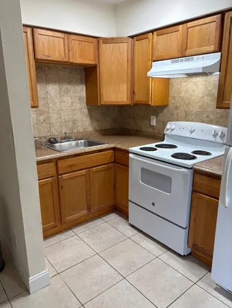 a kitchen with a stove sink and cabinets