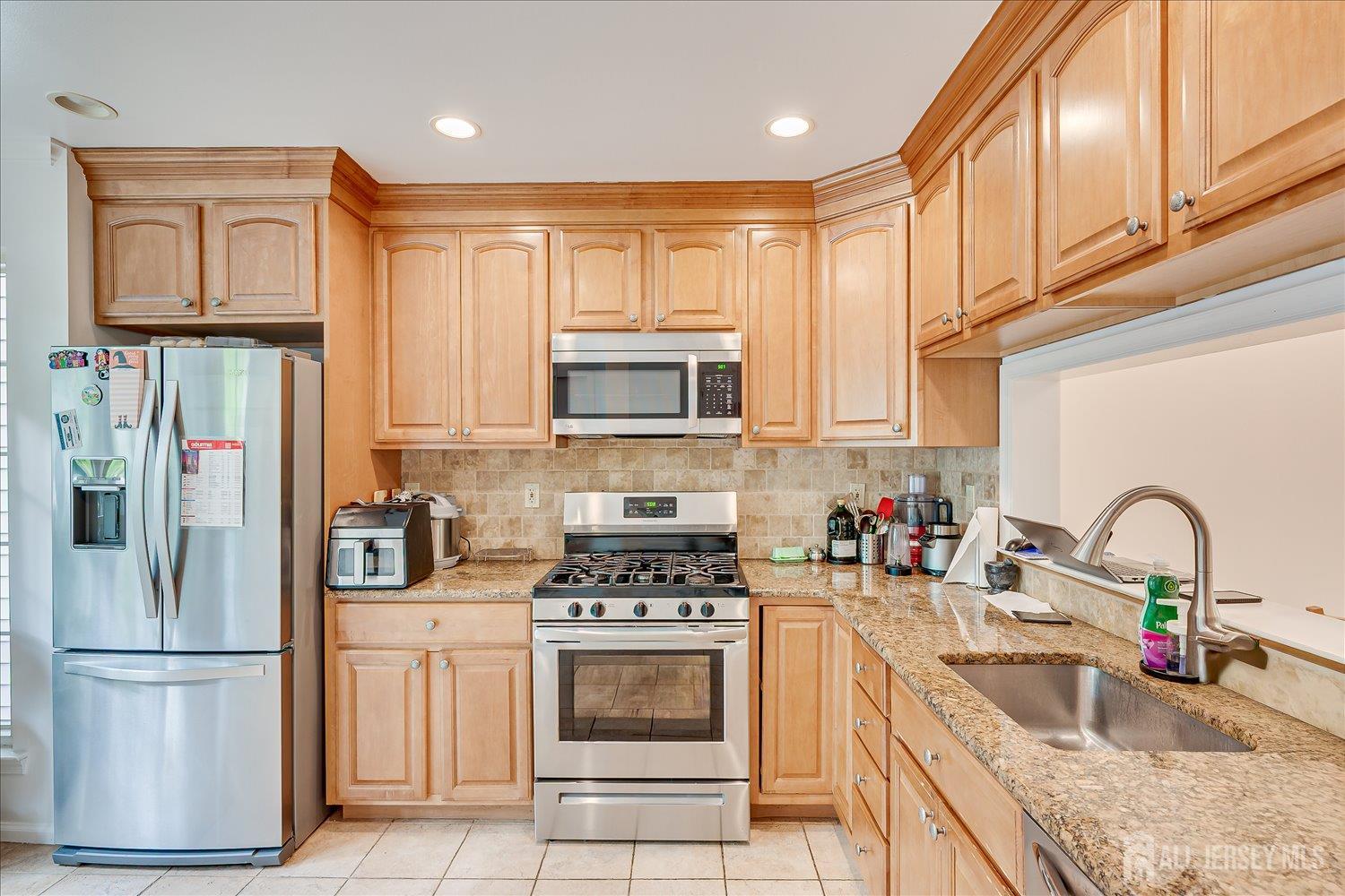903 Maplecrest Road Edison, NJ 08820 - Photo 3 of 24 a kitchen with stainless steel appliances granite countertop a refrigerator sink and cabinets
