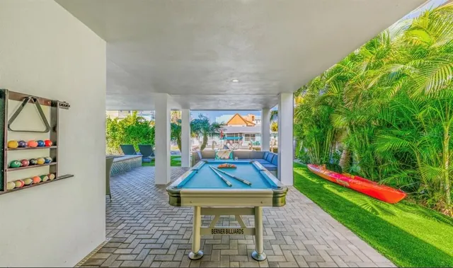a view of a patio with table and chairs potted plants with floor to ceiling window