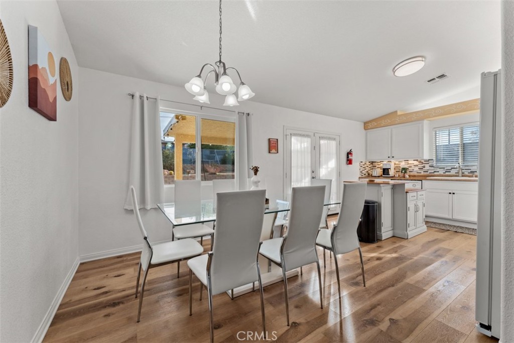60205 Latham Trail Joshua Tree, CA 92252 - Photo 11 of 38 a view of a dining room with furniture a chandelier and wooden floor