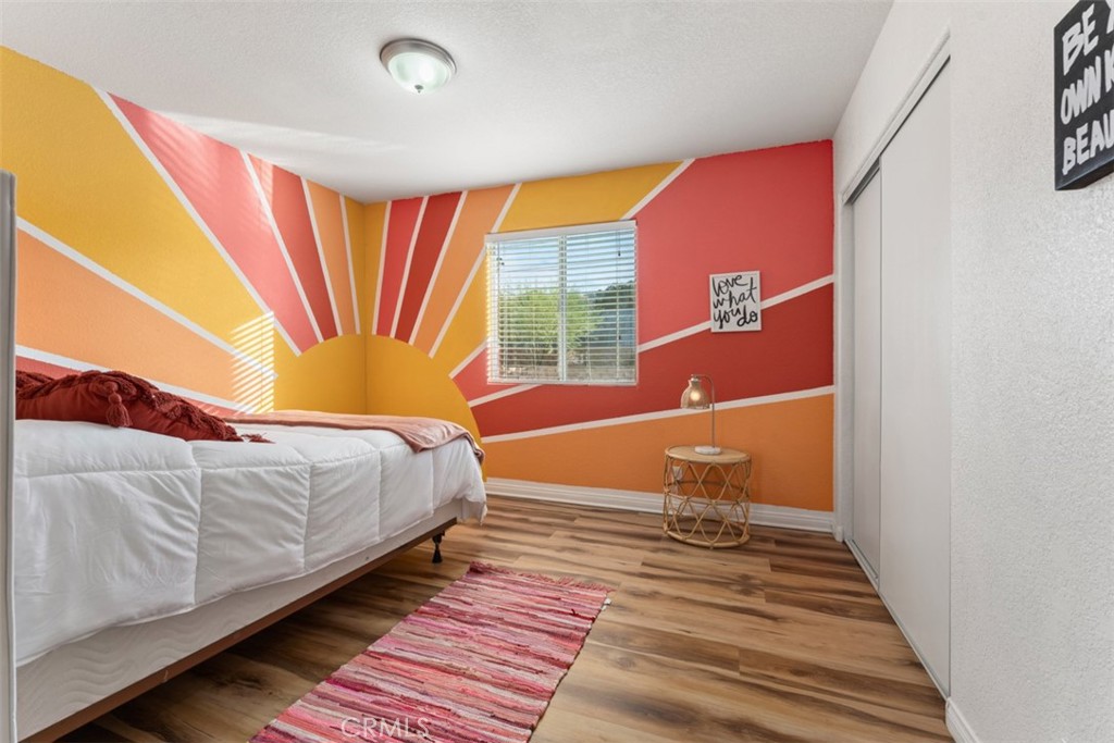 60205 Latham Trail Joshua Tree, CA 92252 - Photo 19 of 38 a bedroom with a bed and wooden floor