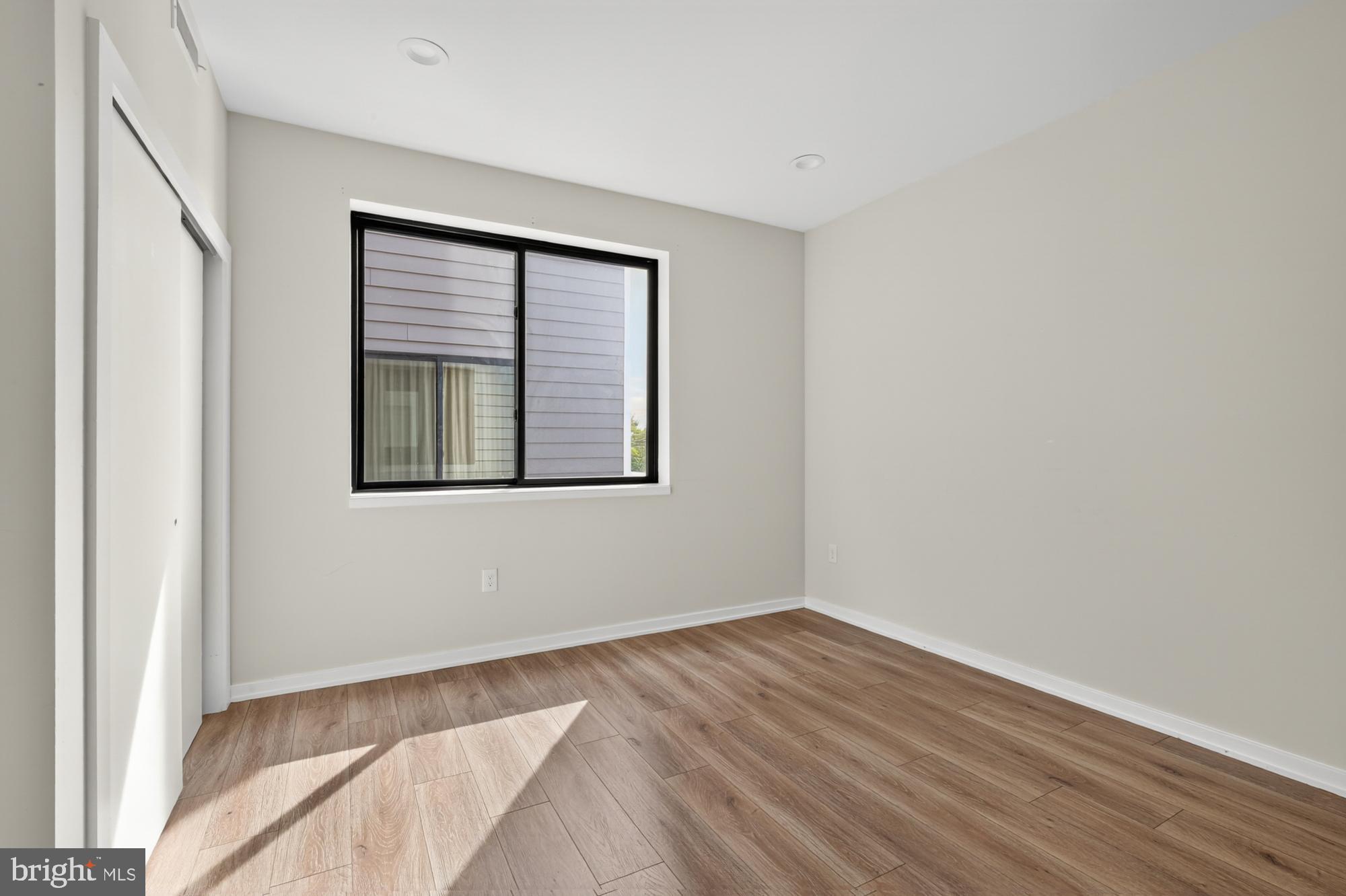 381 Martin Street, Unit 2 Philadelphia, PA 19128 - Photo 12 of 20 a view of an empty room with wooden floor and a window