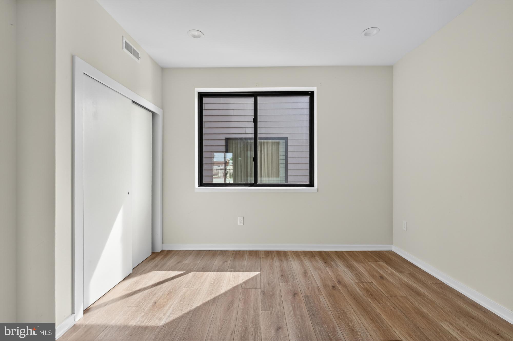 381 Martin Street, Unit 2 Philadelphia, PA 19128 - Photo 13 of 20 a view of an empty room with wooden floor and a window