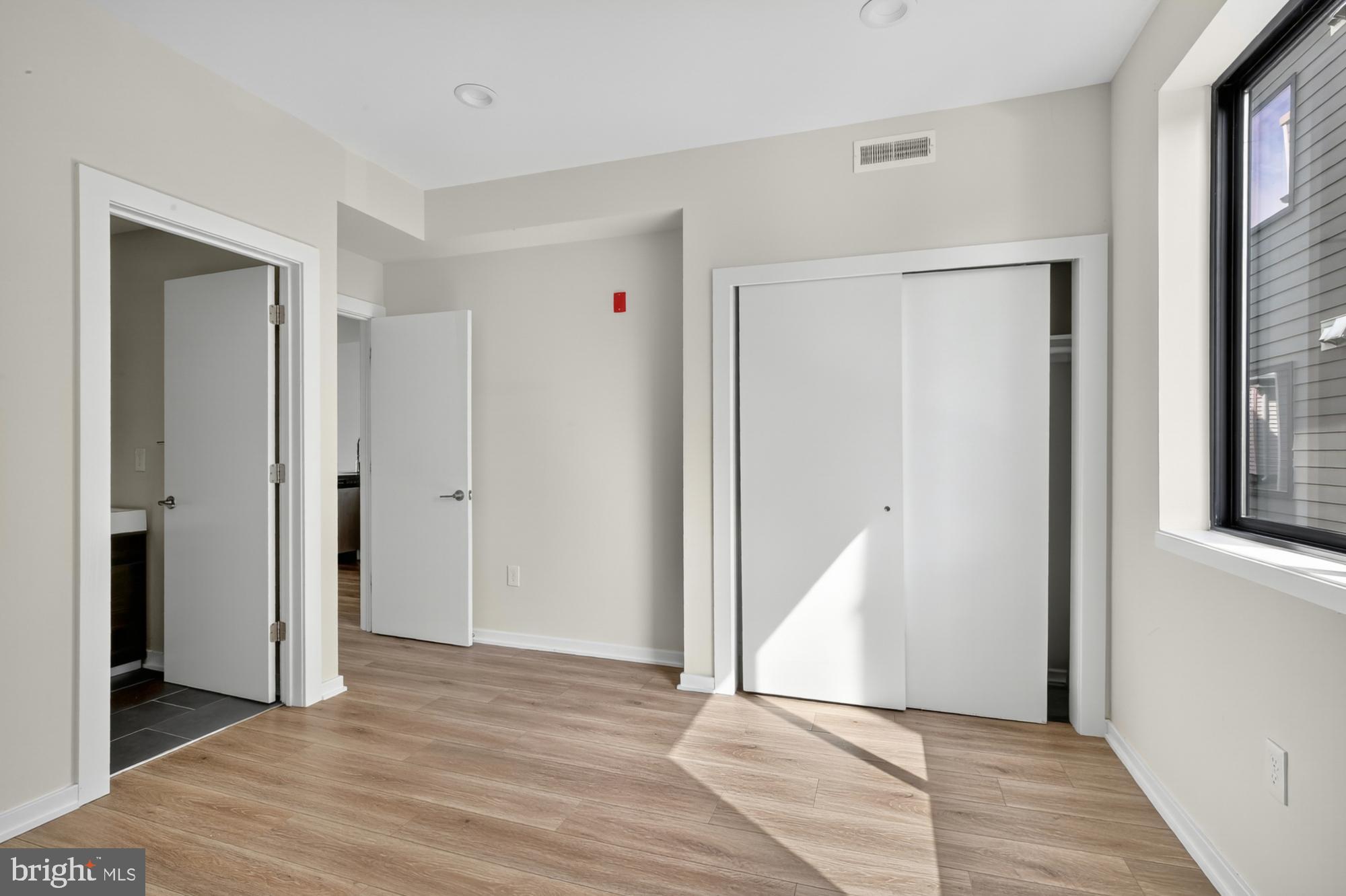 381 Martin Street, Unit 2 Philadelphia, PA 19128 - Photo 14 of 20 a view of an empty room with wooden floor and a window