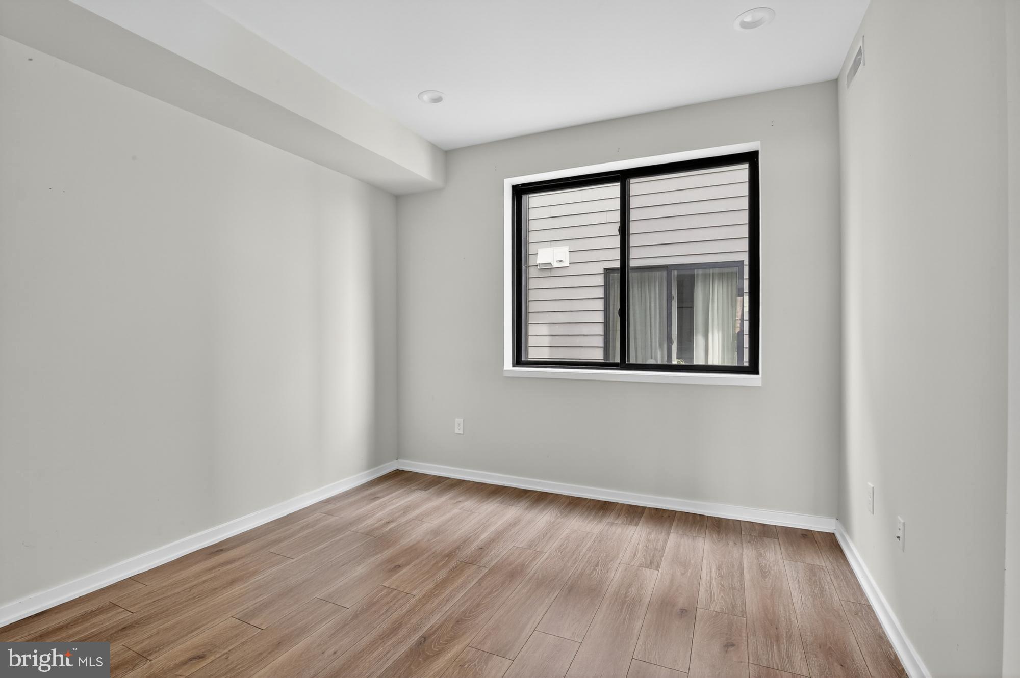381 Martin Street, Unit 2 Philadelphia, PA 19128 - Photo 16 of 20 a view of an empty room with wooden floor and a window