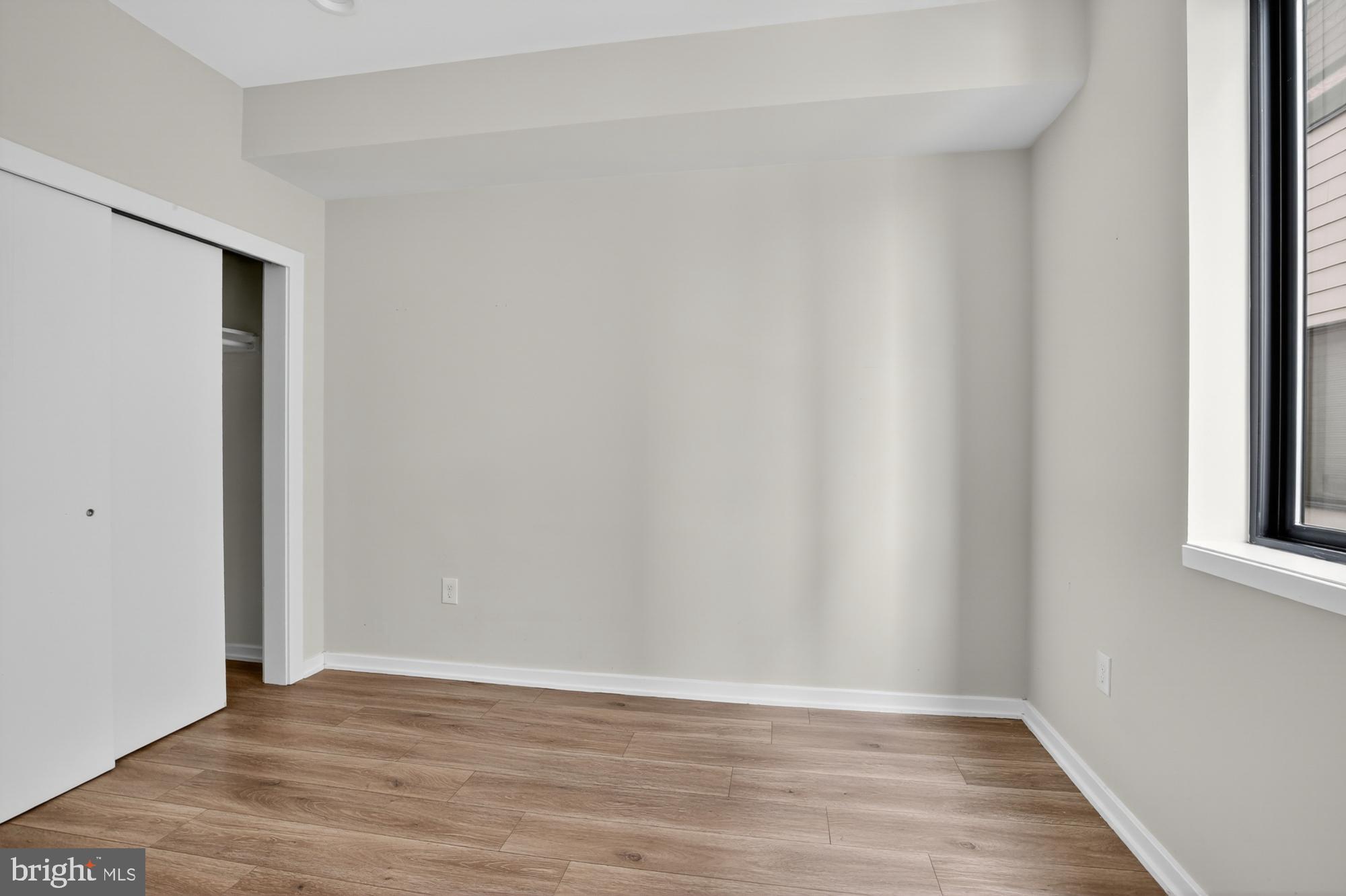 381 Martin Street, Unit 2 Philadelphia, PA 19128 - Photo 18 of 20 a view of an empty room with wooden floor and a window