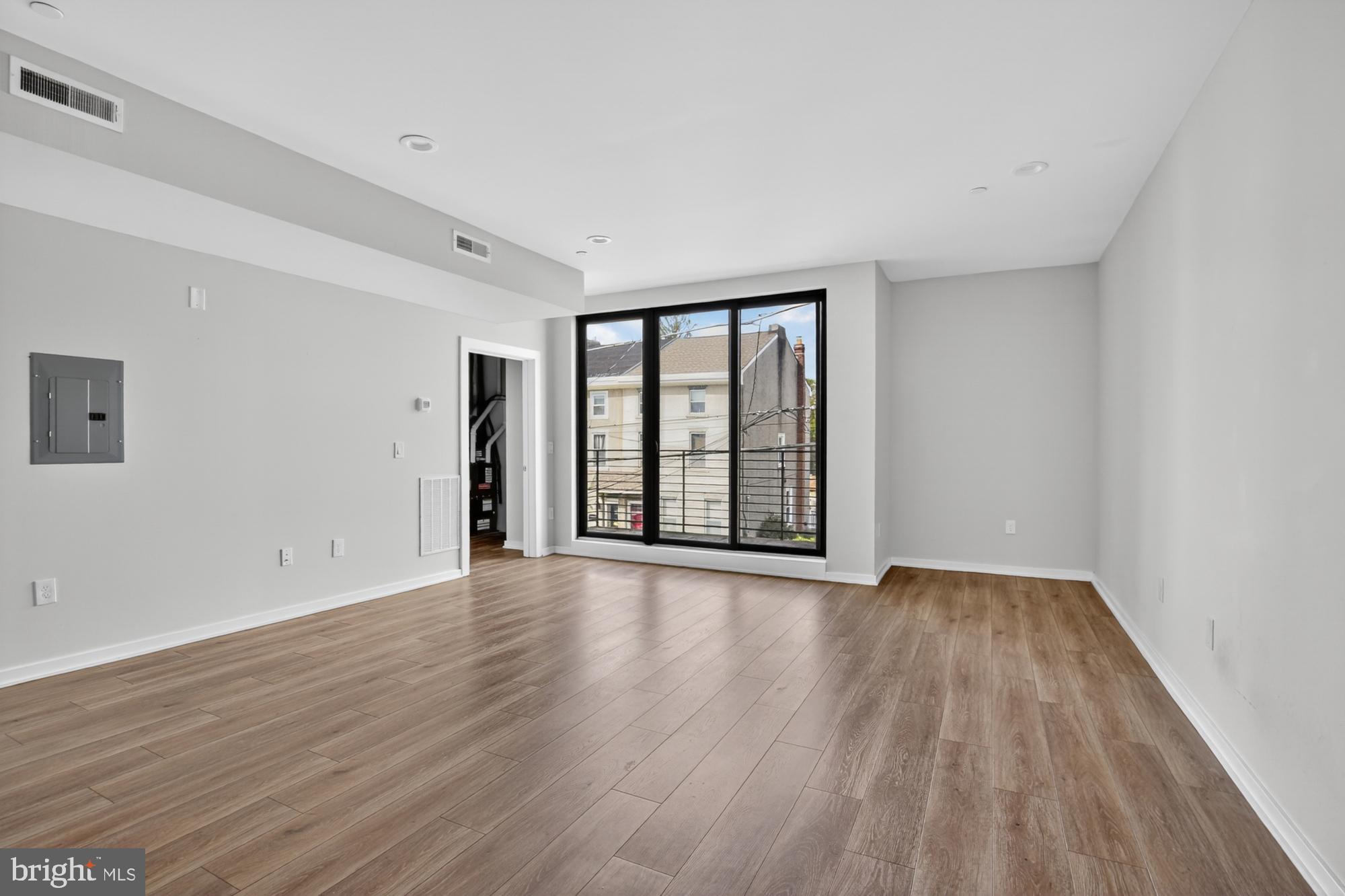 381 Martin Street, Unit 2 Philadelphia, PA 19128 - Photo 6 of 20 a view of an empty room with wooden floor and a window