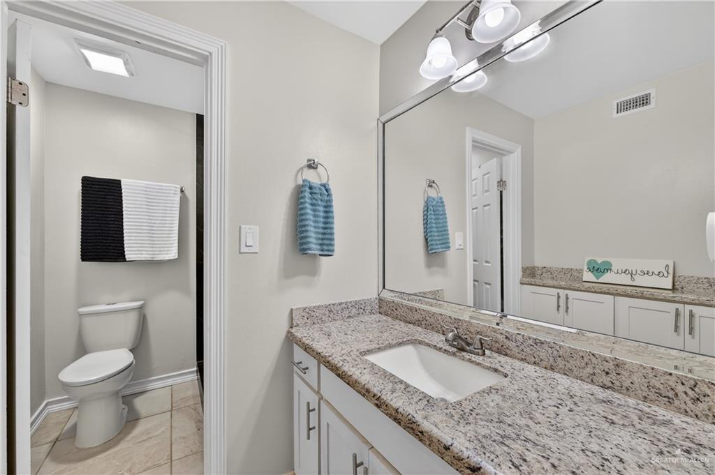 500 Wichita Avenue McAllen, TX 78503 - Photo 12 of 22 a bathroom with a granite countertop sink a toilet and a mirror
