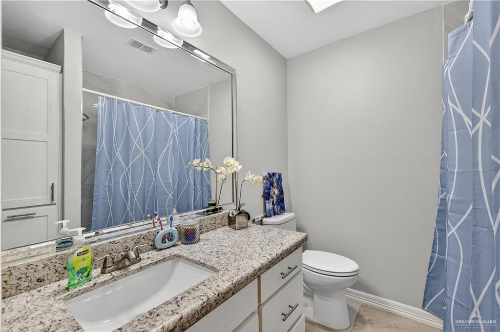 500 Wichita Avenue McAllen, TX 78503 - Photo 15 of 22 a bathroom with a granite countertop sink a toilet and a mirror