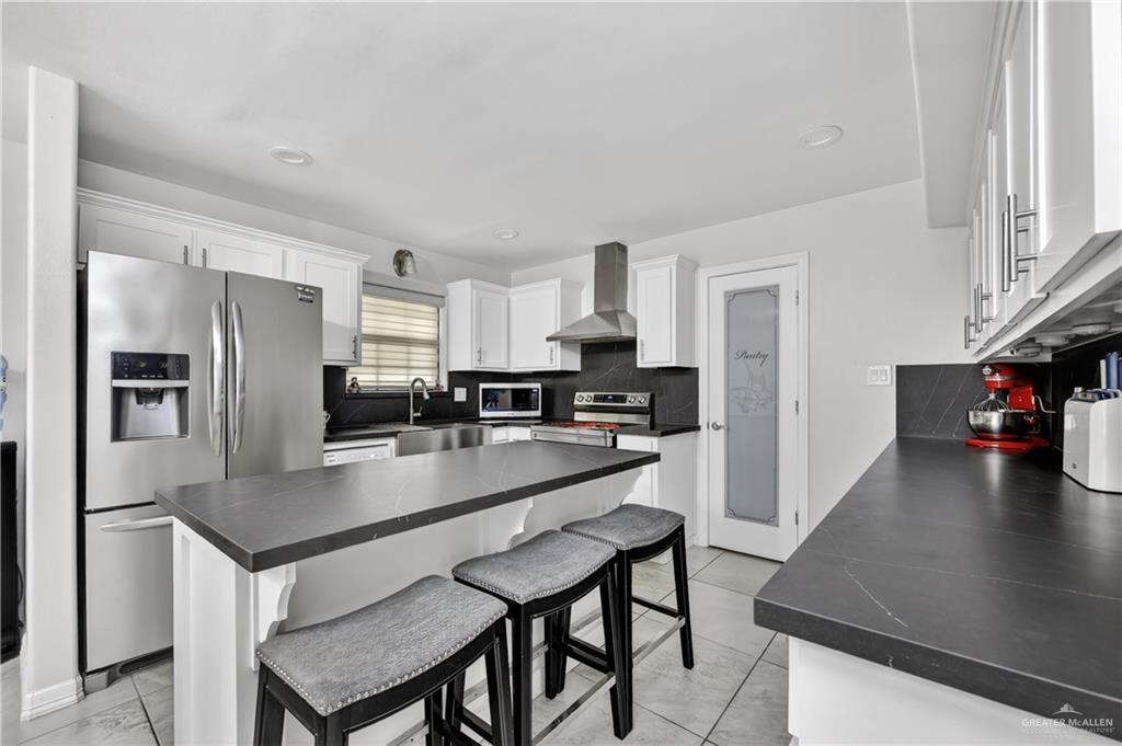 500 Wichita Avenue McAllen, TX 78503 - Photo 4 of 22 a kitchen with stainless steel appliances granite countertop a refrigerator a stove a sink a dining table and chairs with wooden floor