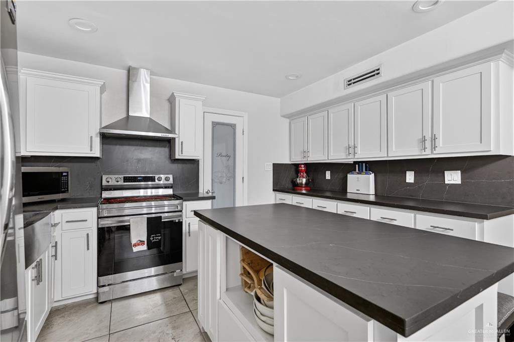 500 Wichita Avenue McAllen, TX 78503 - Photo 6 of 22 a kitchen with stainless steel appliances granite countertop a stove a sink and a microwave