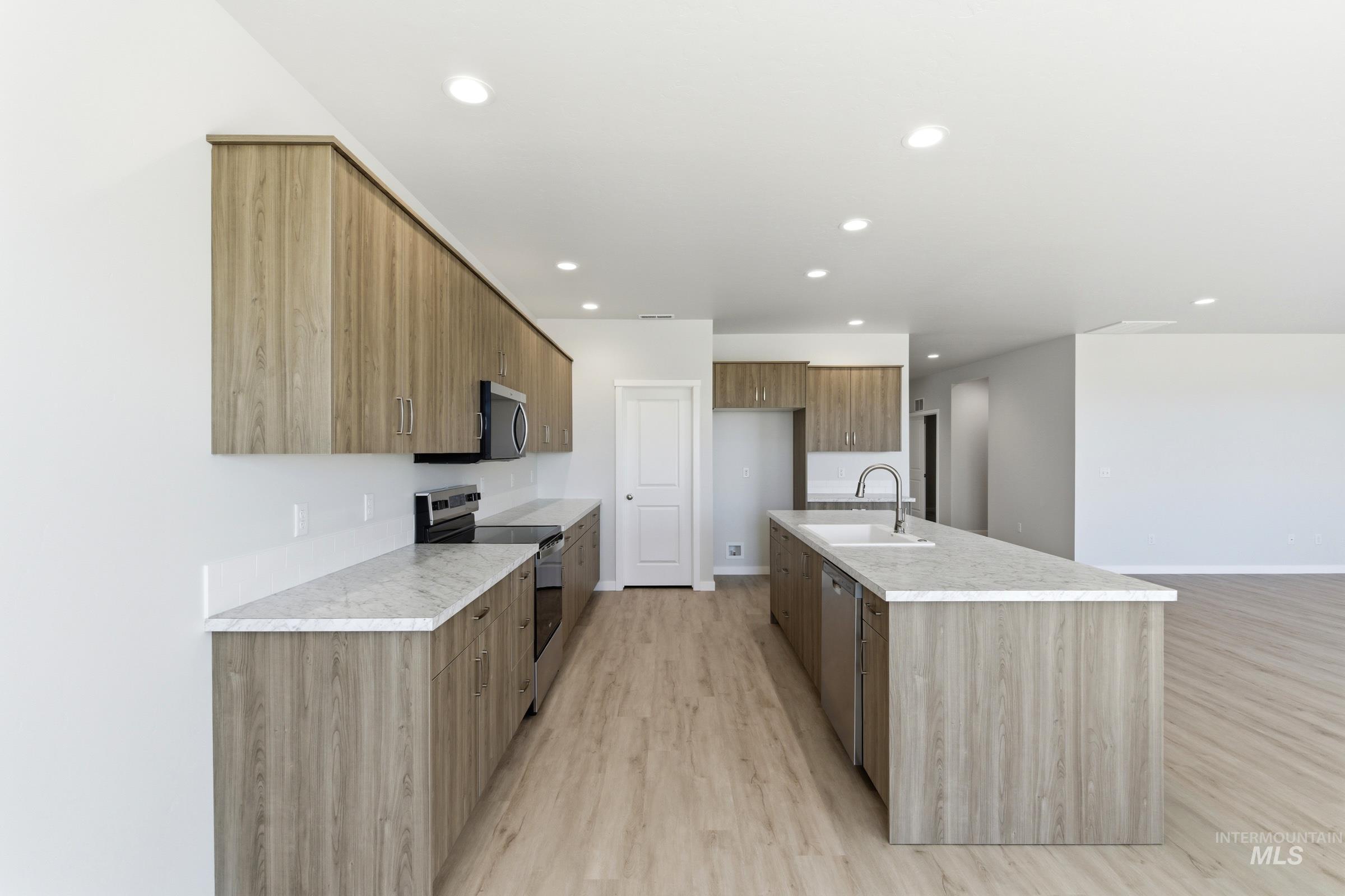 13663 Redway Court Caldwell, ID 83607 - Photo 6 of 32 Modern kitchen featuring light wood-finish cabinetry and light-toned countertops
