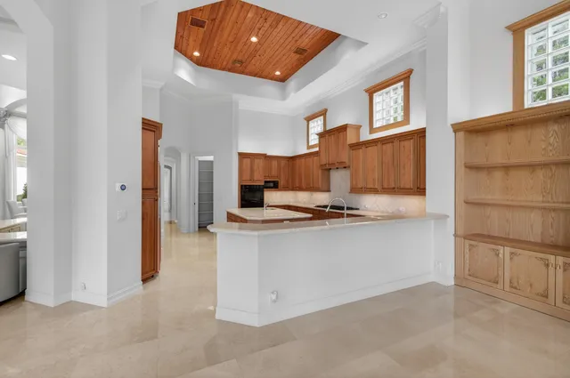 a view of a swimming pool with a yard and palm trees