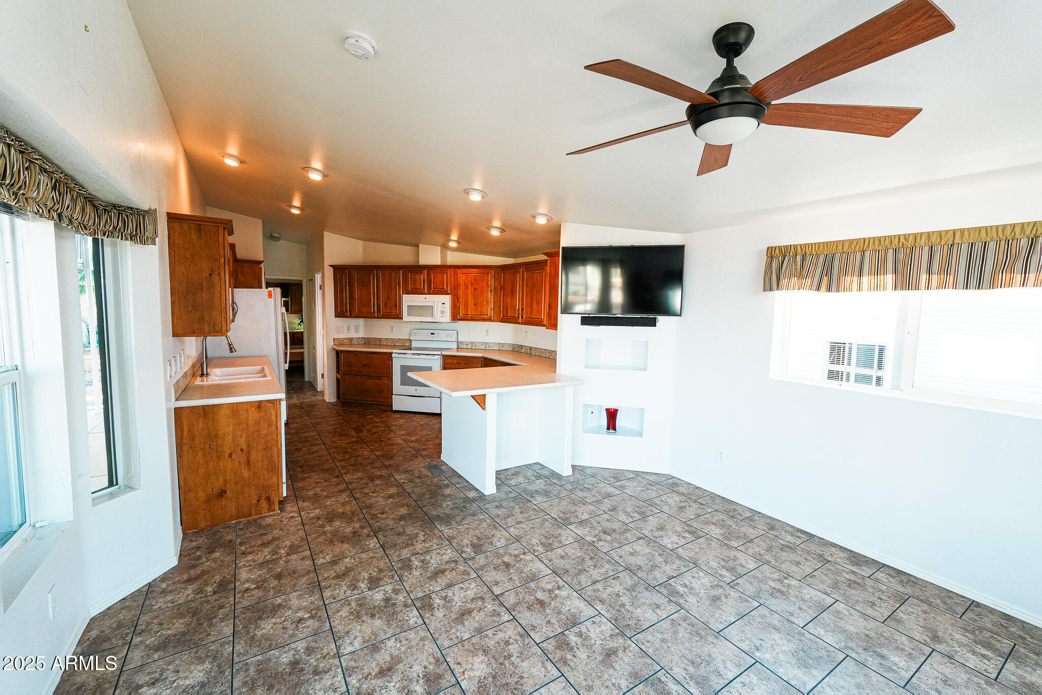 17200 West Bell Road, Unit 330 Surprise, AZ 85374 - Photo 14 of 39 a kitchen with stainless steel appliances kitchen island granite countertop a refrigerator and a stove top oven