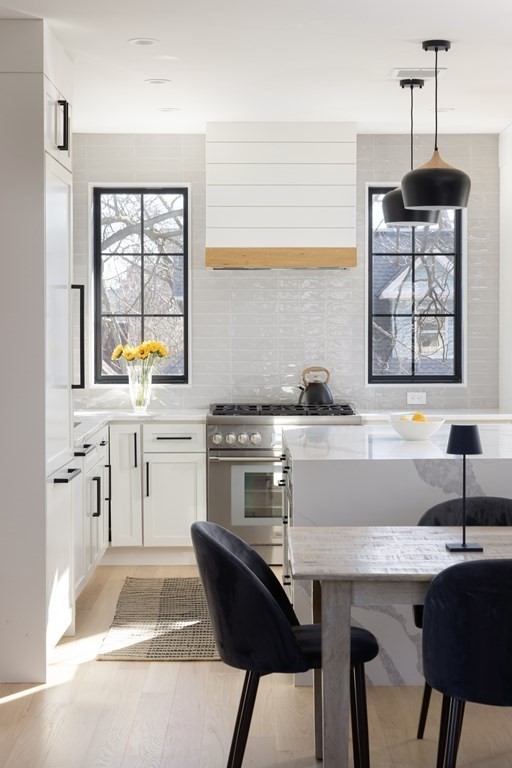 21 Naples Road, Unit 2 Brookline, MA 02446 - Photo 2 of 21 a kitchen with a table chairs sink and cabinets