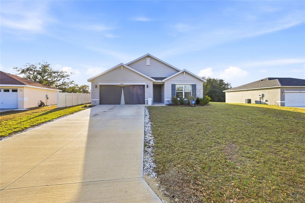 16402 Southwest 17th Terr Road Ocala, FL 34473 - Photo 1 of 36 a front view of a house with large trees and plants