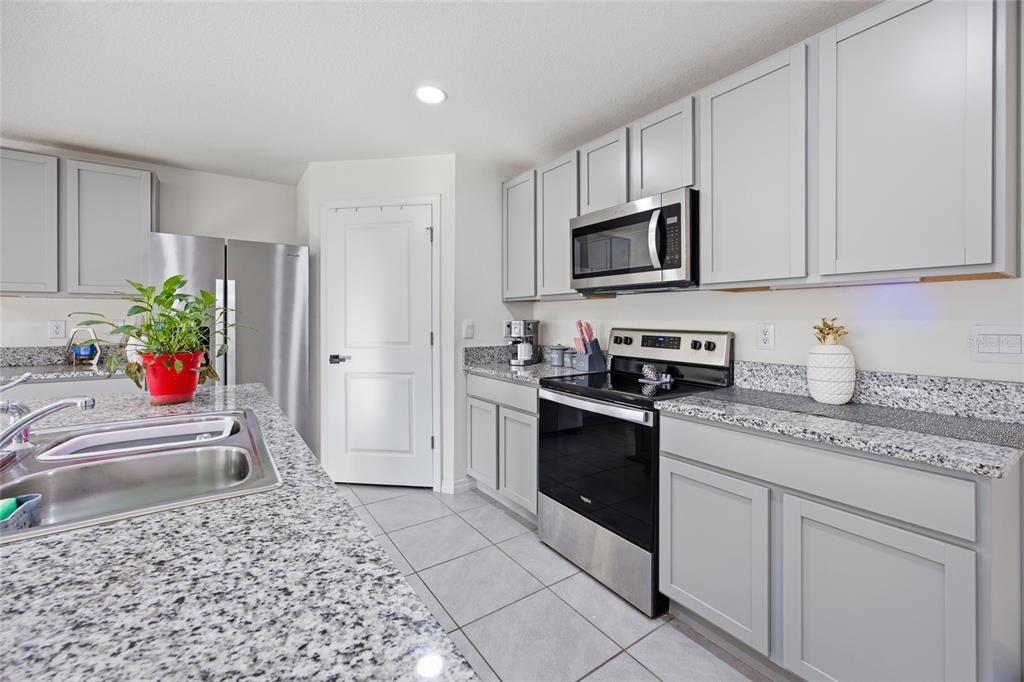 16402 Southwest 17th Terr Road Ocala, FL 34473 - Photo 14 of 36 a kitchen with stainless steel appliances granite countertop a refrigerator sink and stove