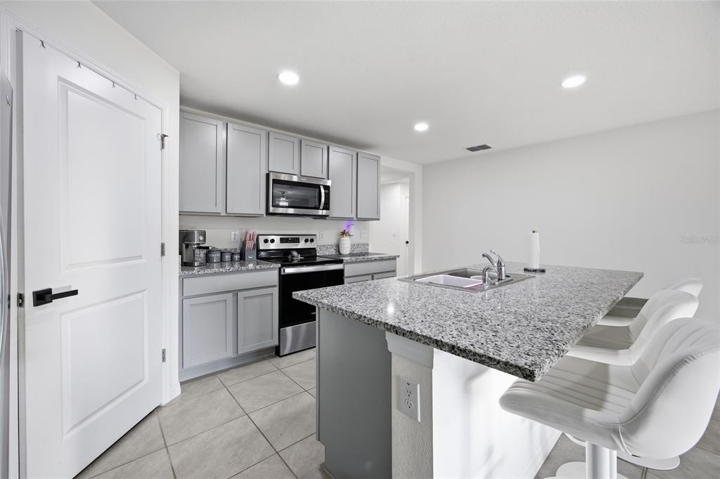 16402 Southwest 17th Terr Road Ocala, FL 34473 - Photo 15 of 36 a kitchen with a sink a microwave a refrigerator and cabinets
