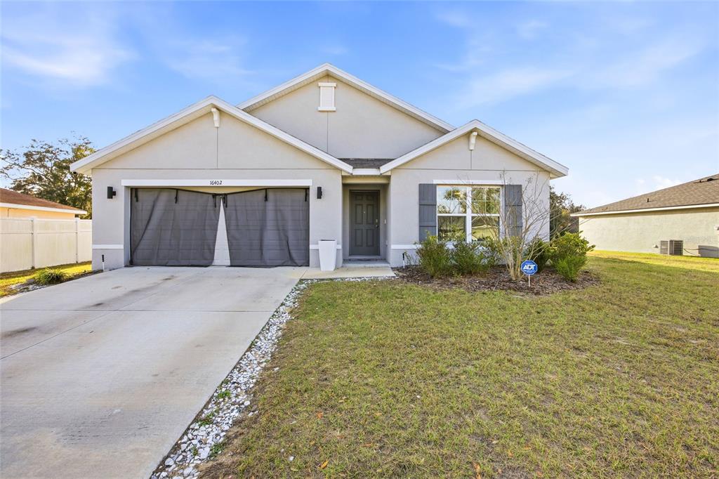 16402 Southwest 17th Terr Road Ocala, FL 34473 - Photo 2 of 36 a front view of a house with a yard and garage