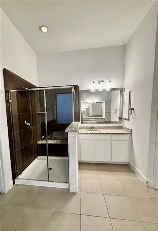 a bathroom with a tub a double vanity sink and mirror
