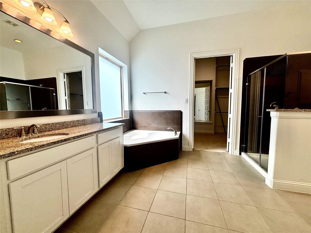 13326 Lake Chesdin Road Houston, TX 77044 - Photo 19 of 29 a bathroom with a tub a double vanity sink and mirror