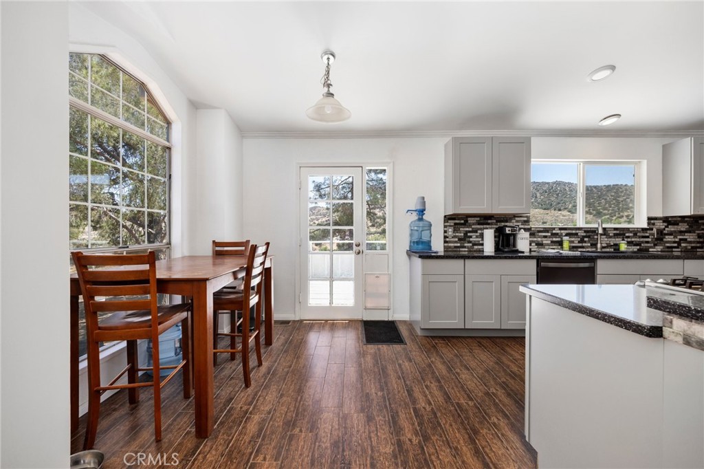 33415 Oracle Hill Road Palmdale, CA 93550 - Photo 11 of 44 a kitchen with stainless steel appliances a table and chairs in it