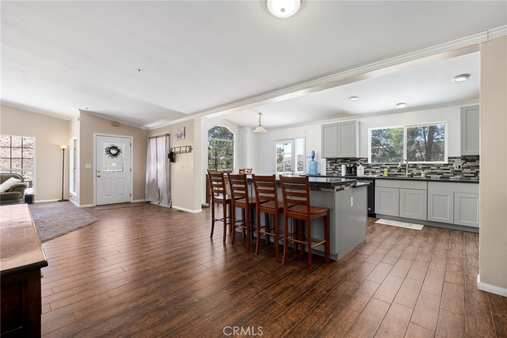 33415 Oracle Hill Road Palmdale, CA 93550 - Photo 13 of 44 a kitchen with stainless steel appliances kitchen island wooden floors and white cabinets