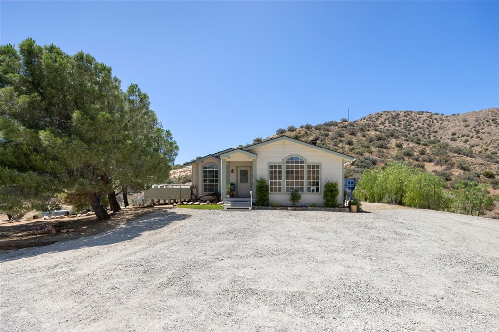 33415 Oracle Hill Road Palmdale, CA 93550 - Photo 3 of 44 a view of a white house with a yard