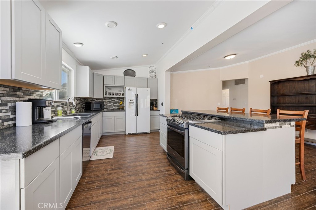 33415 Oracle Hill Road Palmdale, CA 93550 - Photo 9 of 44 a kitchen with stainless steel appliances a sink stove refrigerator and cabinets
