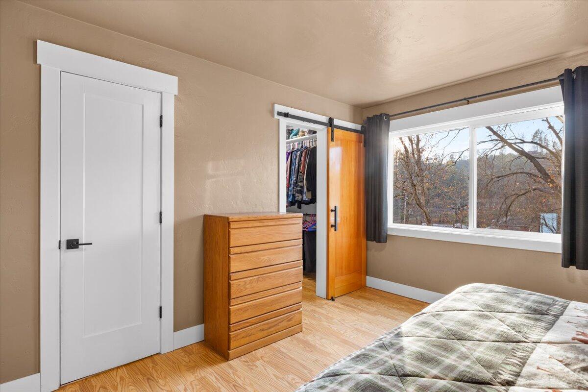 1360 Oxyoke Road Grants Pass, OR 97526 - Photo 21 of 39 a view of a bedroom with wooden floor and a window
