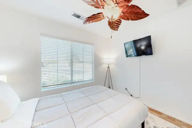 a bedroom with a bed and a flat screen tv