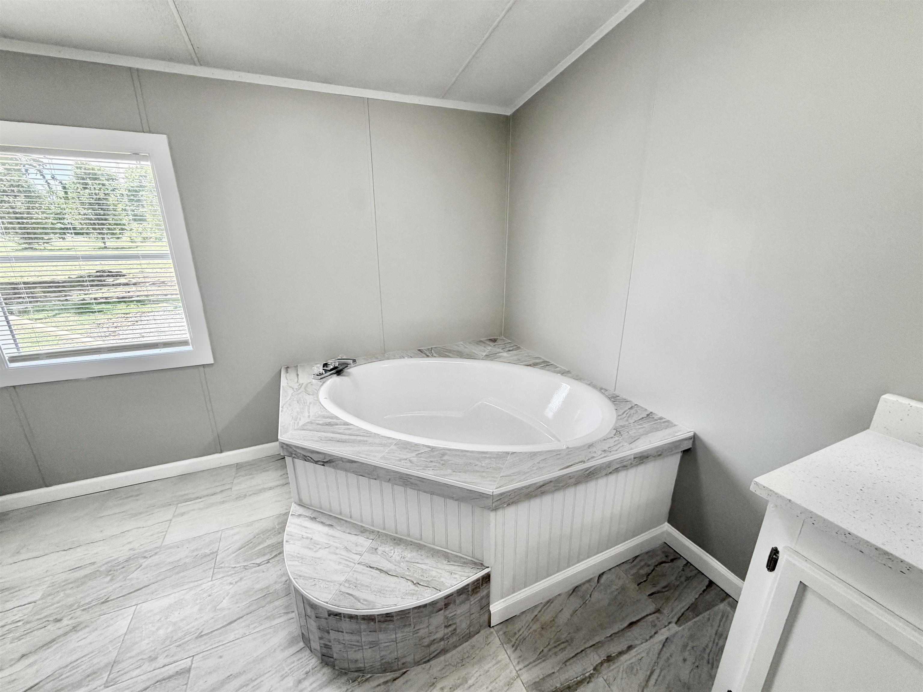 1655 Fayne Road Brighton, TN 38011 - Photo 21 of 28 Corner soaking tub with a tiled surround and an integrated step