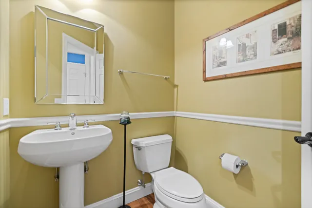 a bathroom with a toilet sink and mirror